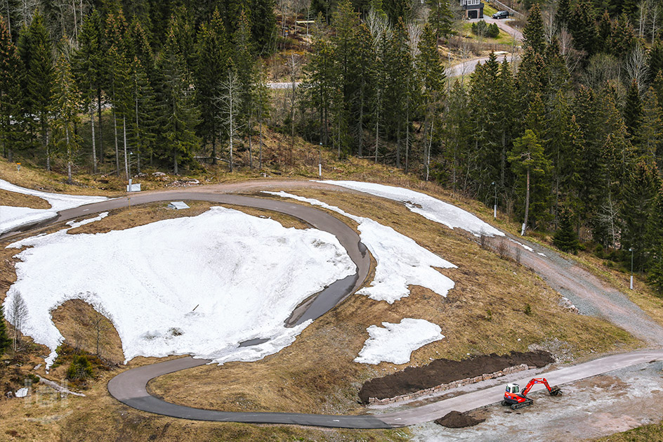 Aussicht vom Sprungturm des Holmenkollen in eine Waldlichtung mit einem letzten Klecks Schnee