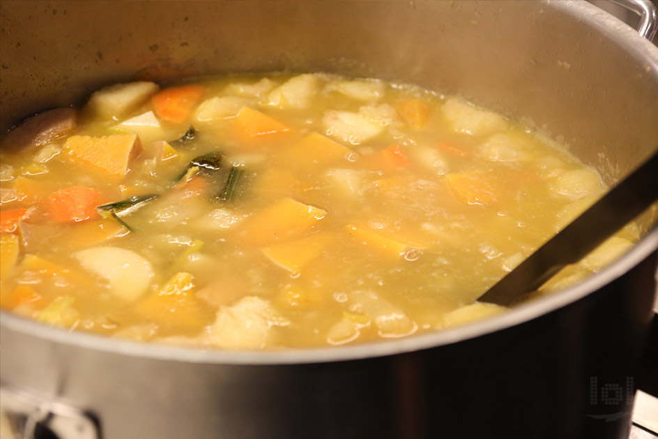 Kürbis und anderes Gemüse für Kürbiscremesuppe kochen